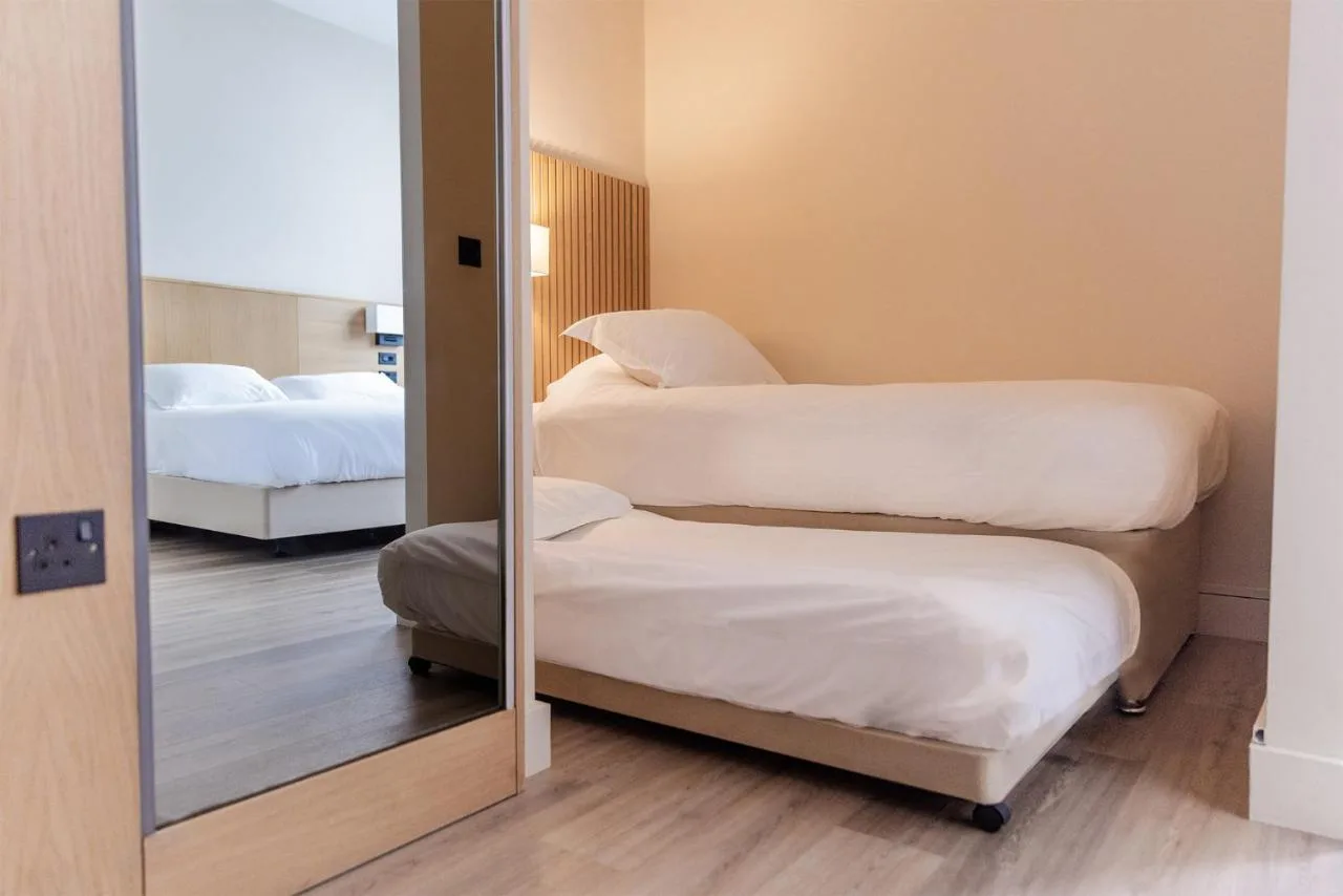 a mirror in a room with two beds at School Lane Hotel in Liverpool ONE in Liverpool