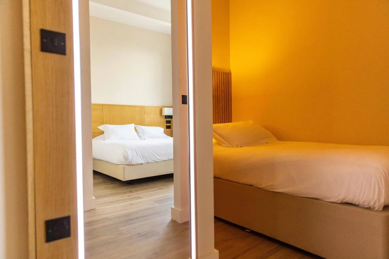 a bedroom with yellow walls and a bed and a mirror at School Lane Hotel in Liverpool ONE in Liverpool